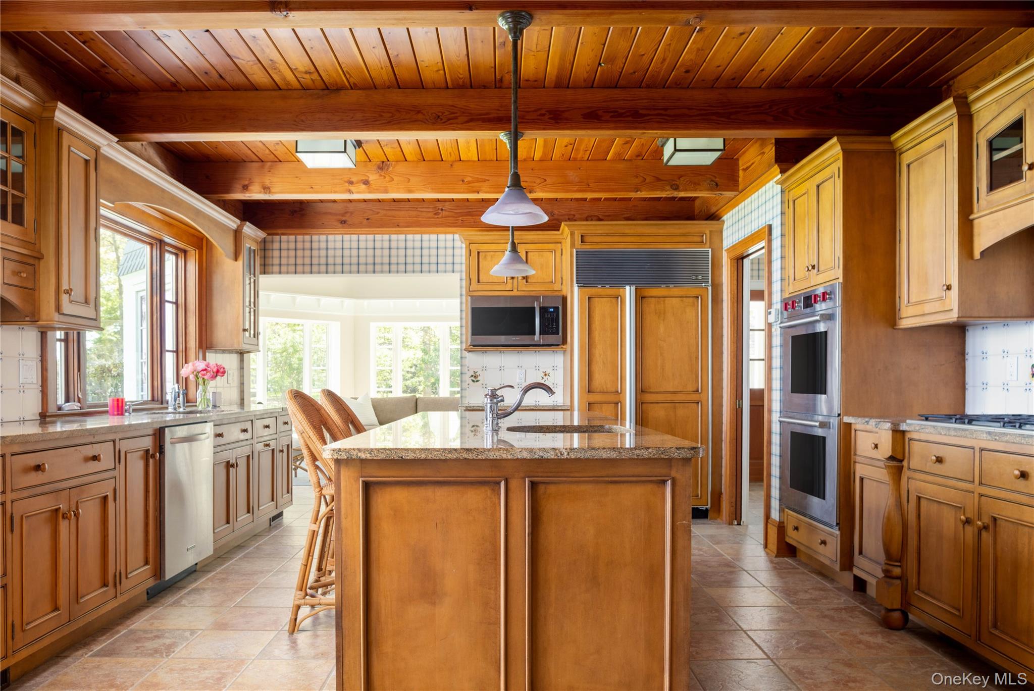 5055 New Suffolk Road New Suffolk, NY 11956 - Photo 17 of 42 a dining hall with stainless steel appliances granite countertop a stove a sink dishwasher and a refrigerator with wooden floor