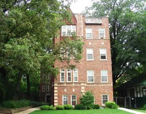 a view of a brick building next to a yard