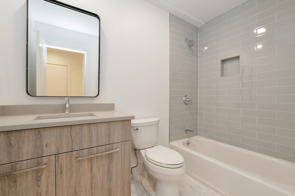 55 East Springfield Street, Unit 4 Boston, MA 02118 - Photo 11 of 16 a bathroom with a toilet a sink a mirror and bathtub