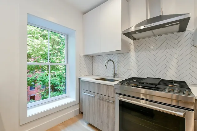 a kitchen with a stove and a white cabinet
