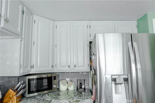 a kitchen with stainless steel appliances granite countertop a sink a stove and a wooden cabinets