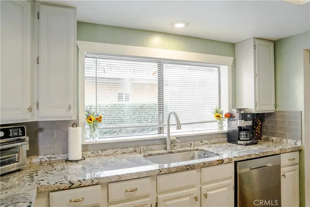 a kitchen with stainless steel appliances granite countertop a sink stove and cabinets