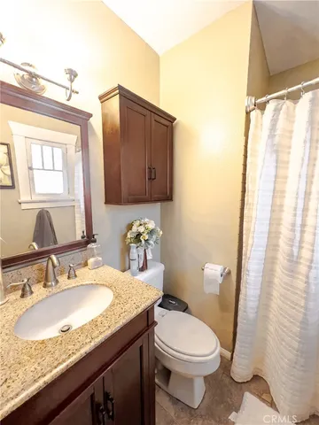 a bathroom with a granite countertop sink a mirror a bathtub and shower