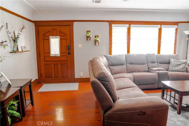 a dining room with furniture potted plants and wooden floor