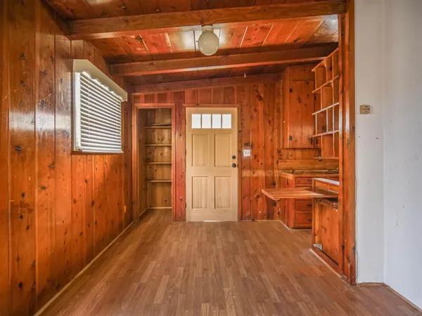 a view of a hallway with wooden floor and staircase