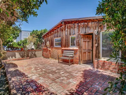 a backyard of a house with barbeque oven table and chairs