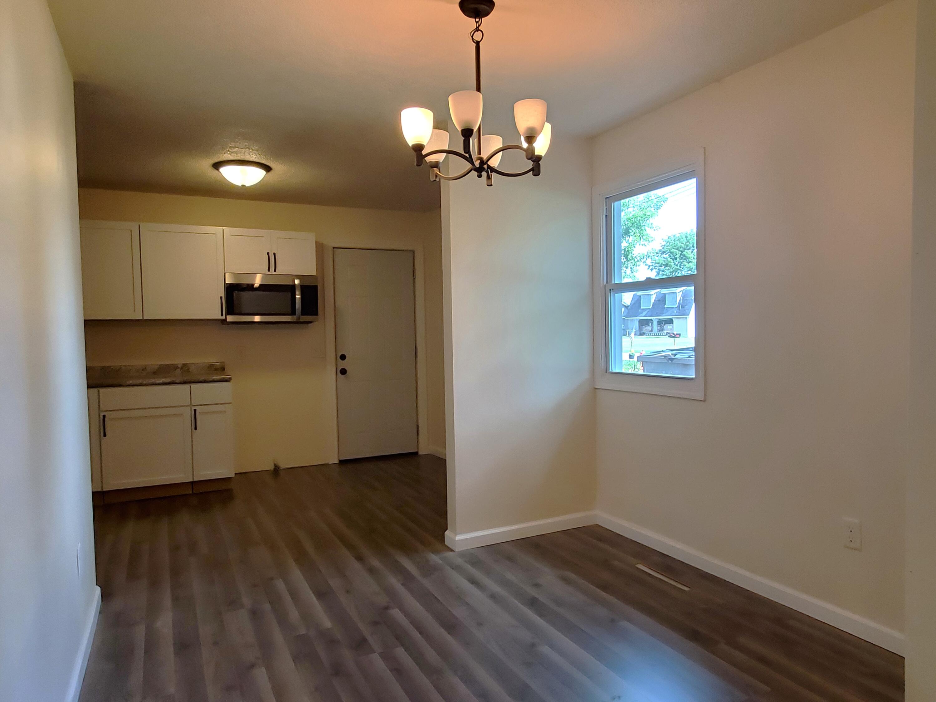 218 West Allen Street Kentland, IN 47951 - Photo 5 of 11 a kitchen that has a microwave a stove and a wooden floors