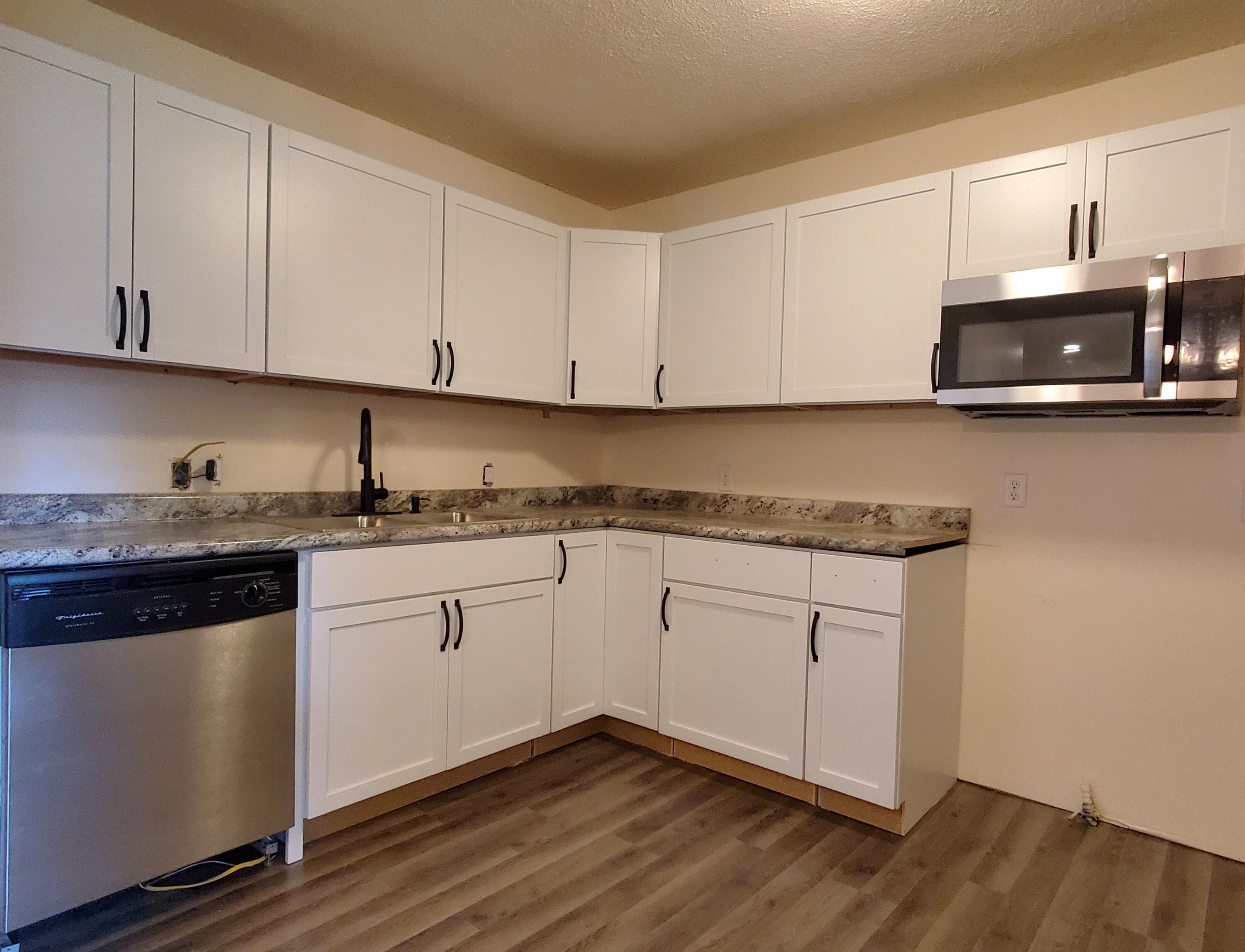 218 West Allen Street Kentland, IN 47951 - Photo 7 of 11 a kitchen with granite countertop white cabinets and white appliances