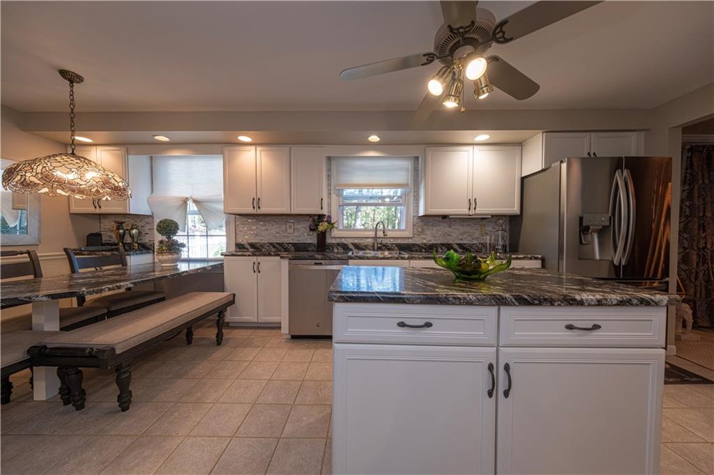 2174 Ramsey Road Monroeville, PA 15146 - Photo 13 of 44 a kitchen with kitchen island granite countertop a sink a counter top space appliances and cabinets