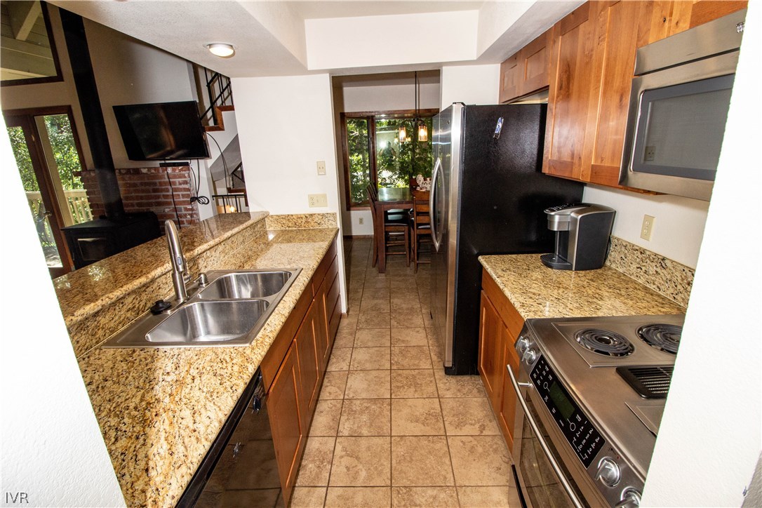 908 Harold Drive, Unit 23 Incline Village, NV 89451 - Photo 5 of 14 a kitchen with kitchen island granite countertop a refrigerator stove and sink