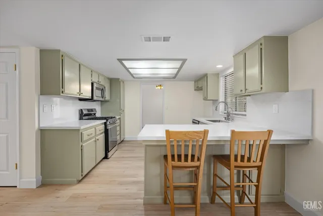 a kitchen with a sink cabinets and wooden floor