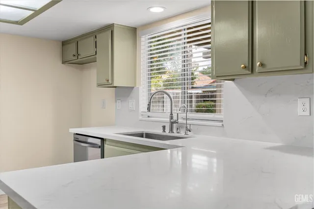 a kitchen with stainless steel appliances granite countertop a stove top oven a sink dishwasher and a refrigerator with wooden floor