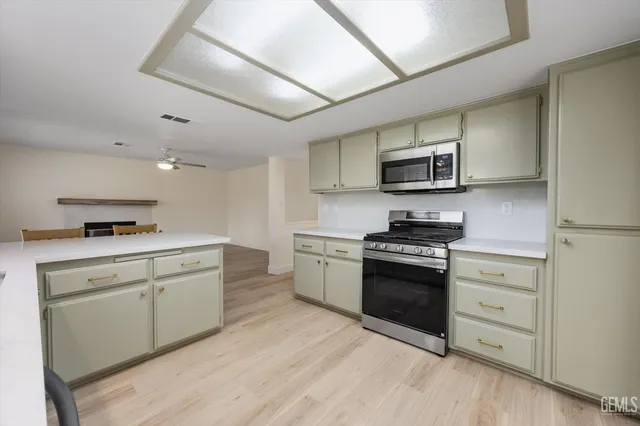 an empty room with wooden floor ceiling fan and windows