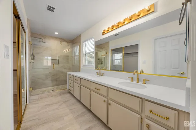 a bathroom with a granite countertop sink vanity mirror and toilet