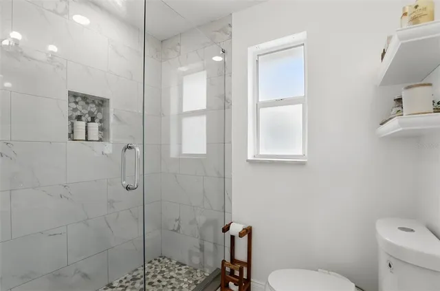 a bathroom with a toilet a sink and mirror