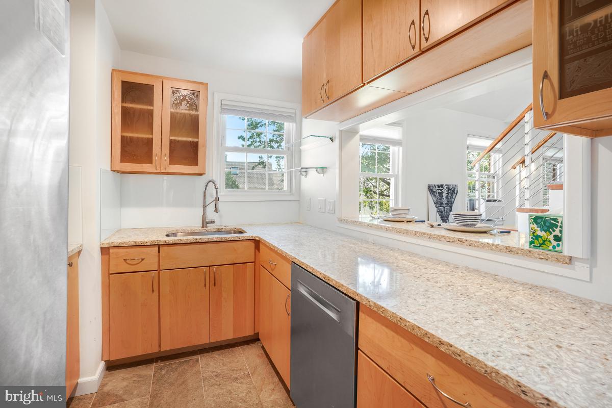 8335 Grubb Road, Unit 203 Silver Spring, MD 20910 - Photo 6 of 29 a kitchen with stainless steel appliances granite countertop a sink and a stove next to a window
