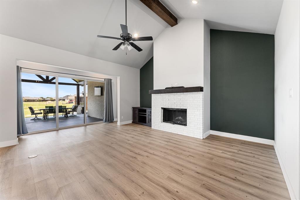1533 Lynx Loop Forney, TX 75126 - Photo 15 of 27 a view of a livingroom with wooden floor a ceiling fan a fireplace and windows