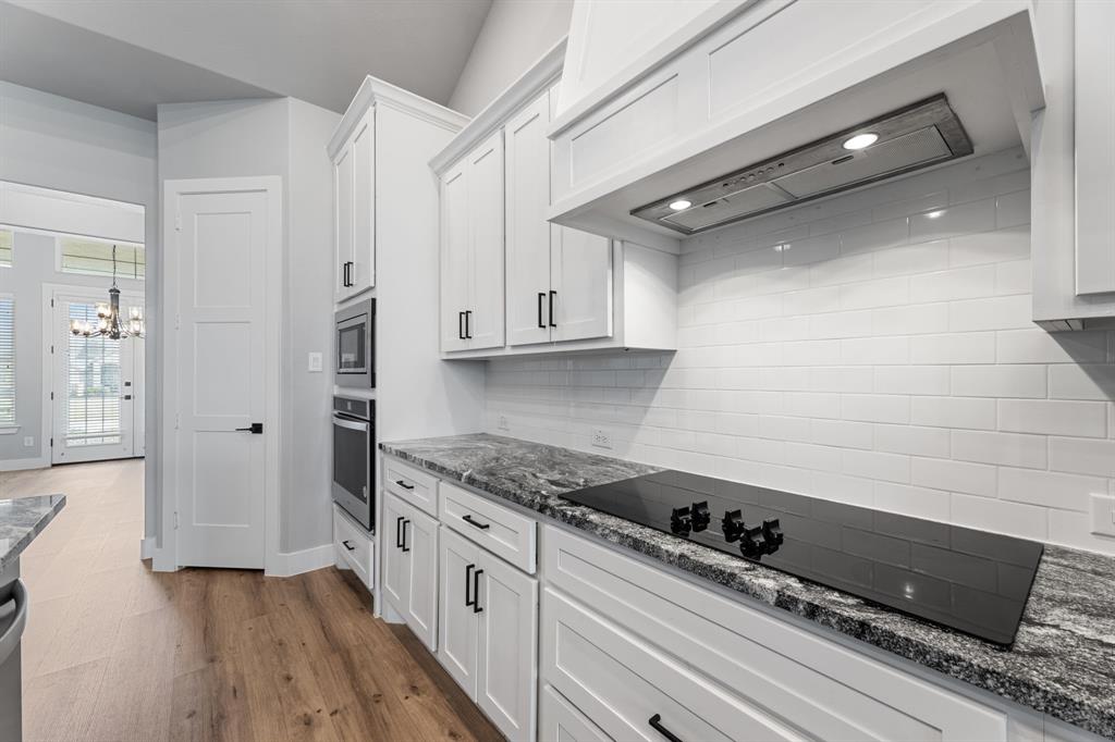 1533 Lynx Loop Forney, TX 75126 - Photo 18 of 27 a kitchen with granite countertop a stove and a refrigerator