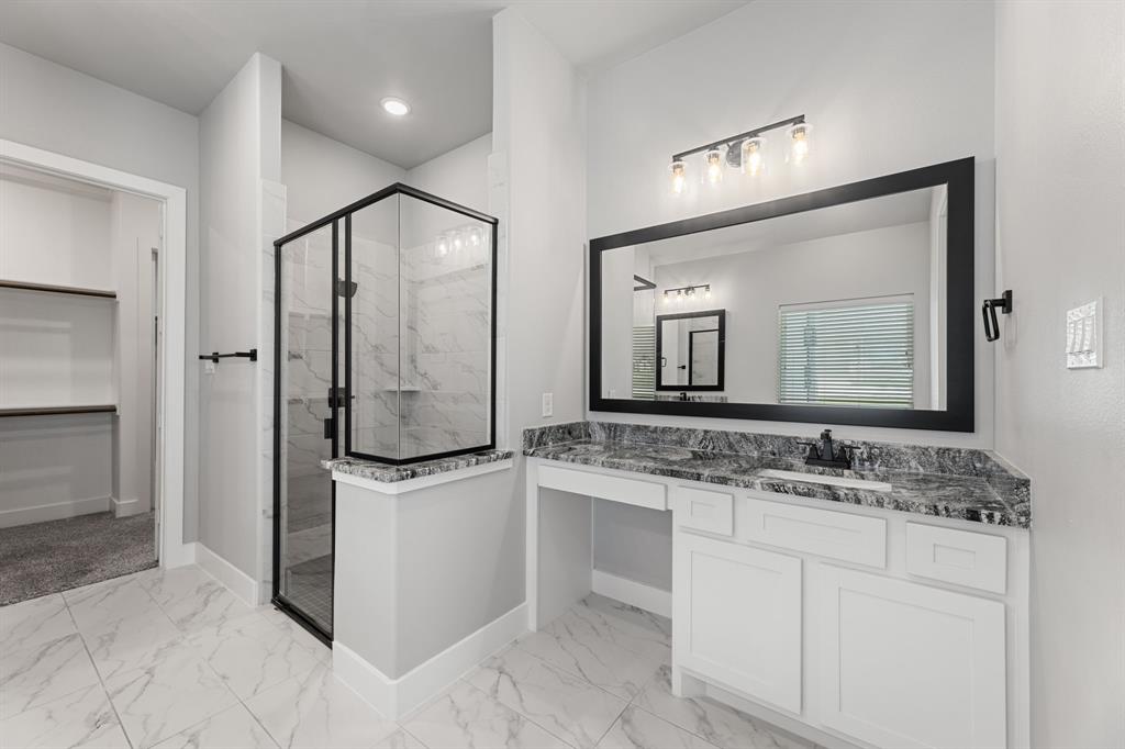 1533 Lynx Loop Forney, TX 75126 - Photo 24 of 27 a bathroom with a granite countertop sink vanity mirror shower and a mirror