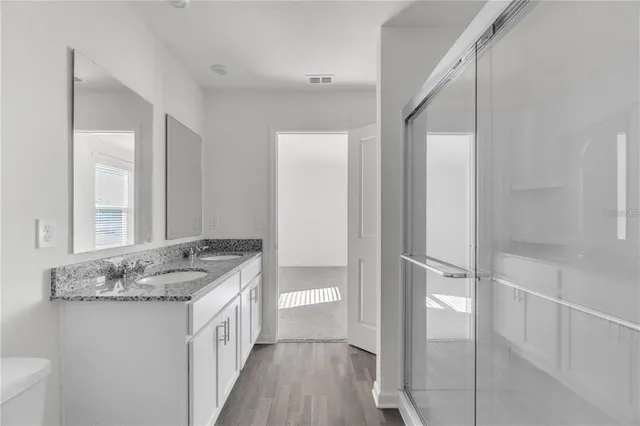 a bathroom with a granite countertop sink and a mirror