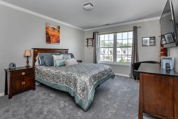 a bedroom with a bed and a table in it with window