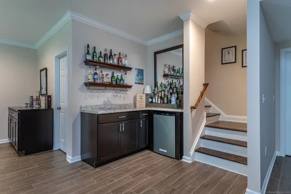 a kitchen with stainless steel appliances granite countertop a refrigerator and a wooden cabinets