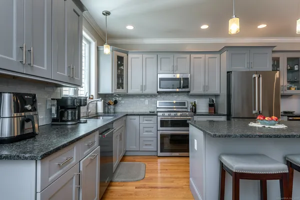 a kitchen with stainless steel appliances granite countertop a stove refrigerator sink and cabinets