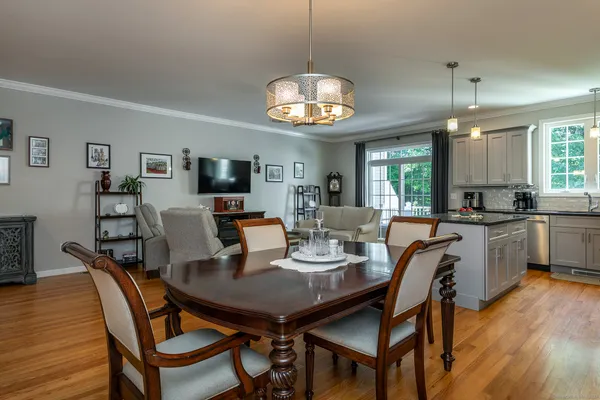 a view of a dining room with furniture a chandelier and wooden floor