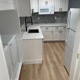 a kitchen with a sink a refrigerator a microwave and cabinets