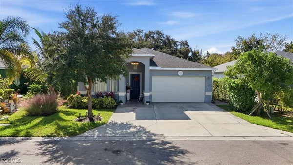 a front view of a house with a yard and potted plants