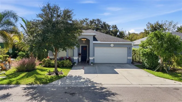 a front view of a house with a yard and potted plants