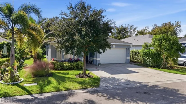 a front view of a house with a yard and a garden