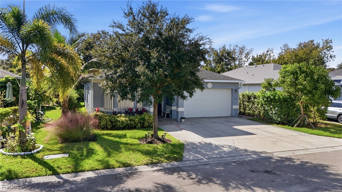 1004 Hamilton Street Immokalee, FL 34142 - Photo 2 of 45 a front view of a house with a yard and a garden