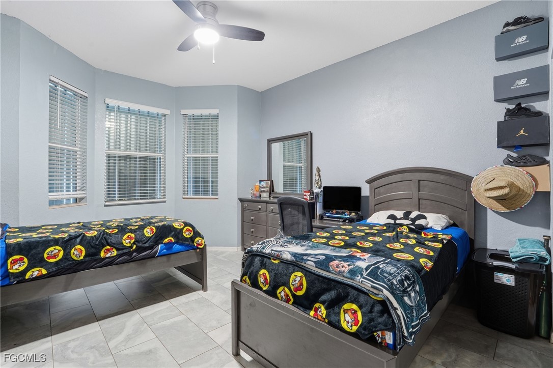 1004 Hamilton Street Immokalee, FL 34142 - Photo 25 of 45 a bedroom with a bed that has a blanket and a chair