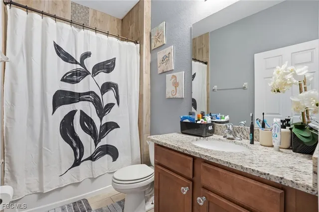 a bathroom with a granite countertop sink a toilet and a mirror