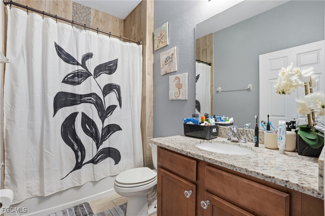 1004 Hamilton Street Immokalee, FL 34142 - Photo 27 of 45 a bathroom with a granite countertop sink a toilet and a mirror