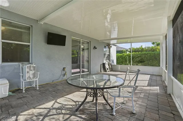 a living room with furniture a flat screen tv and a floor to ceiling window
