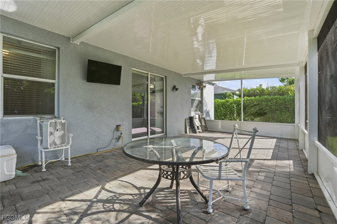 1004 Hamilton Street Immokalee, FL 34142 - Photo 34 of 45 a living room with furniture a flat screen tv and a floor to ceiling window