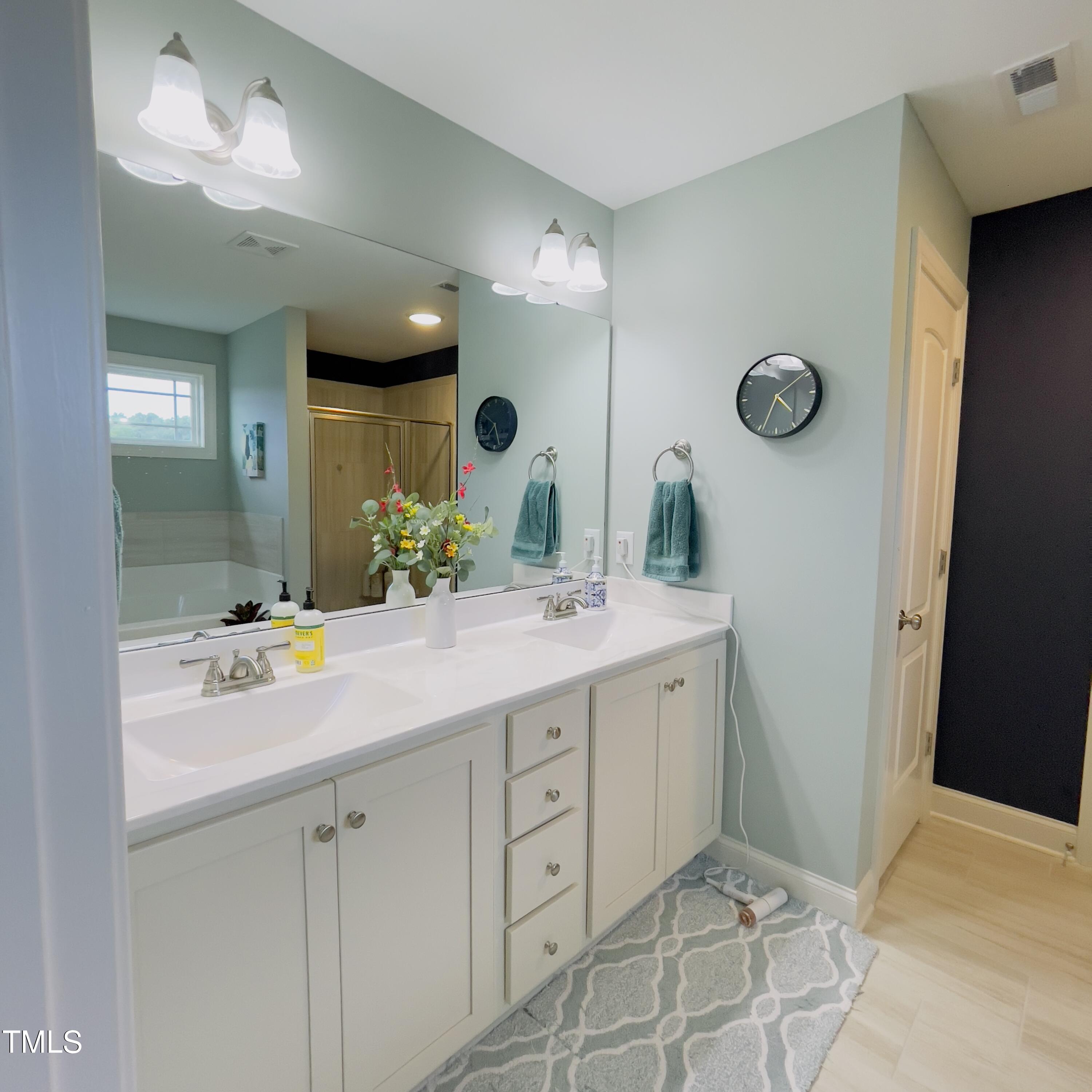 136 Unique Place Garner, NC 27529 - Photo 12 of 21 a bathroom with a double vanity sink and a mirror