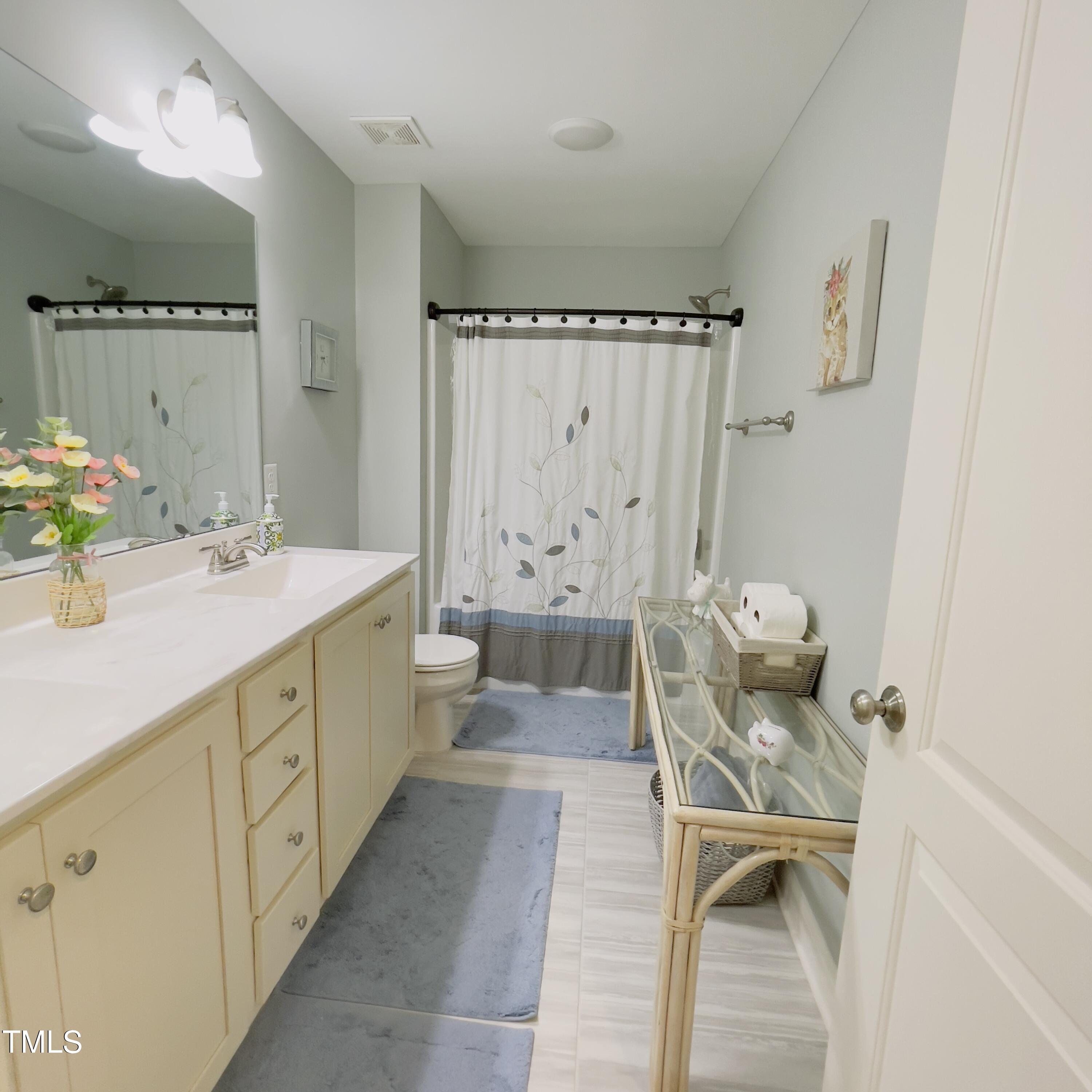 136 Unique Place Garner, NC 27529 - Photo 19 of 21 a bathroom with a double vanity sink toilet and shower