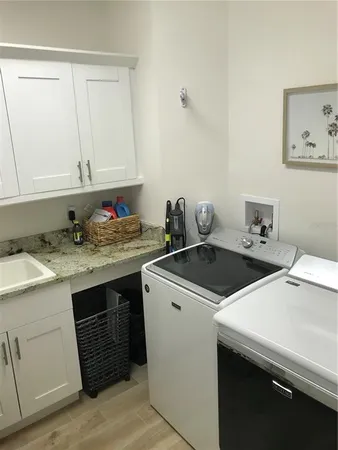 a utility room with sink dryer and washer