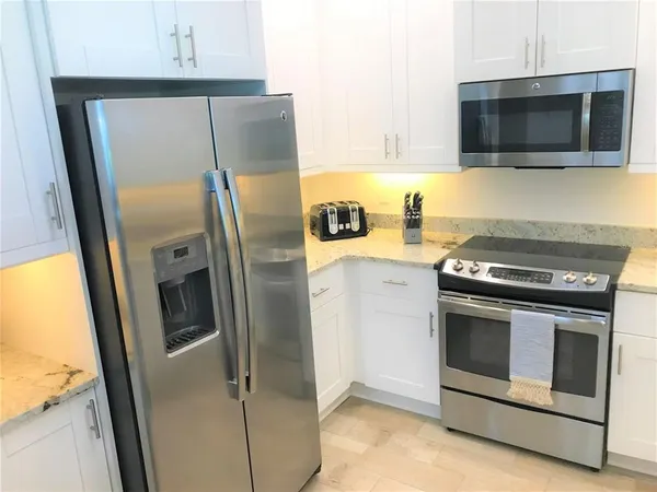a kitchen with stainless steel appliances a refrigerator stove and microwave