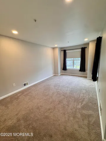 en empty room with windows and fireplace