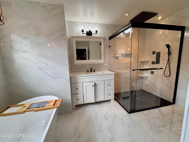 a bathroom with a tub sink and mirror
