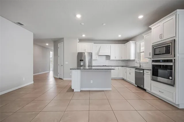 a large kitchen with cabinets stainless steel appliances and a counter space
