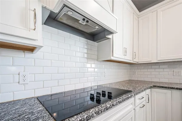 a kitchen with granite countertop white cabinets and white appliances