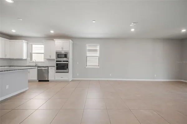 a view of kitchen with a sink stove and cabinets