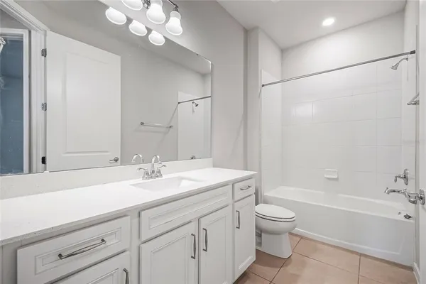 a bathroom with a sink a toilet and a large mirror