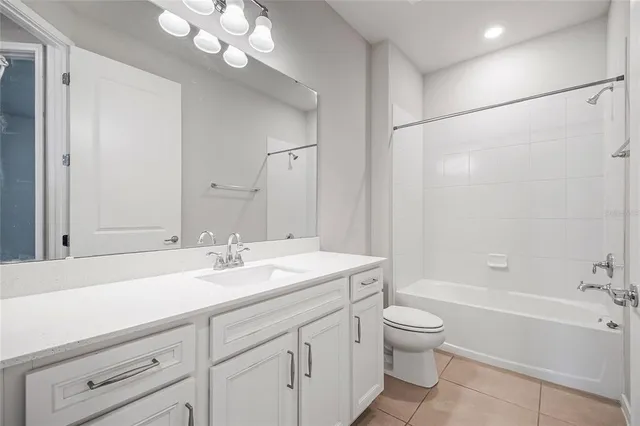 a bathroom with a sink a toilet and a large mirror