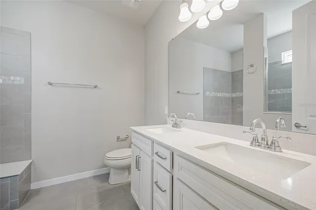 a bathroom with a sink a toilet and a mirror